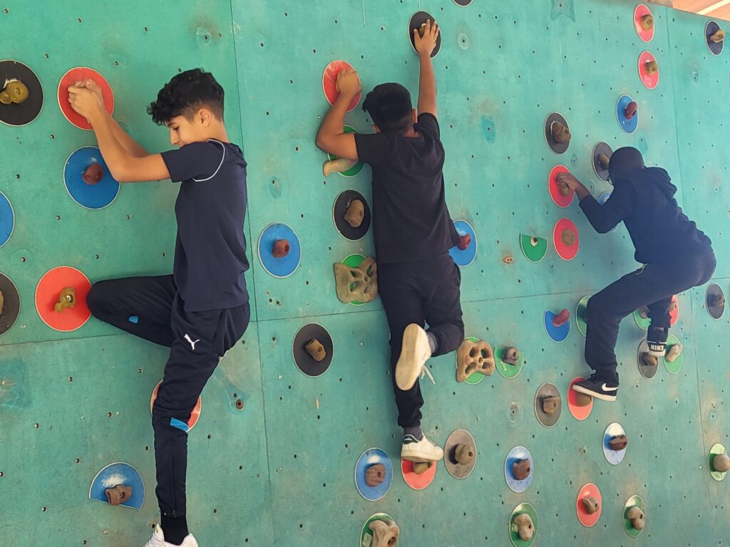 Bambini in arrampicata su parete artificiale
